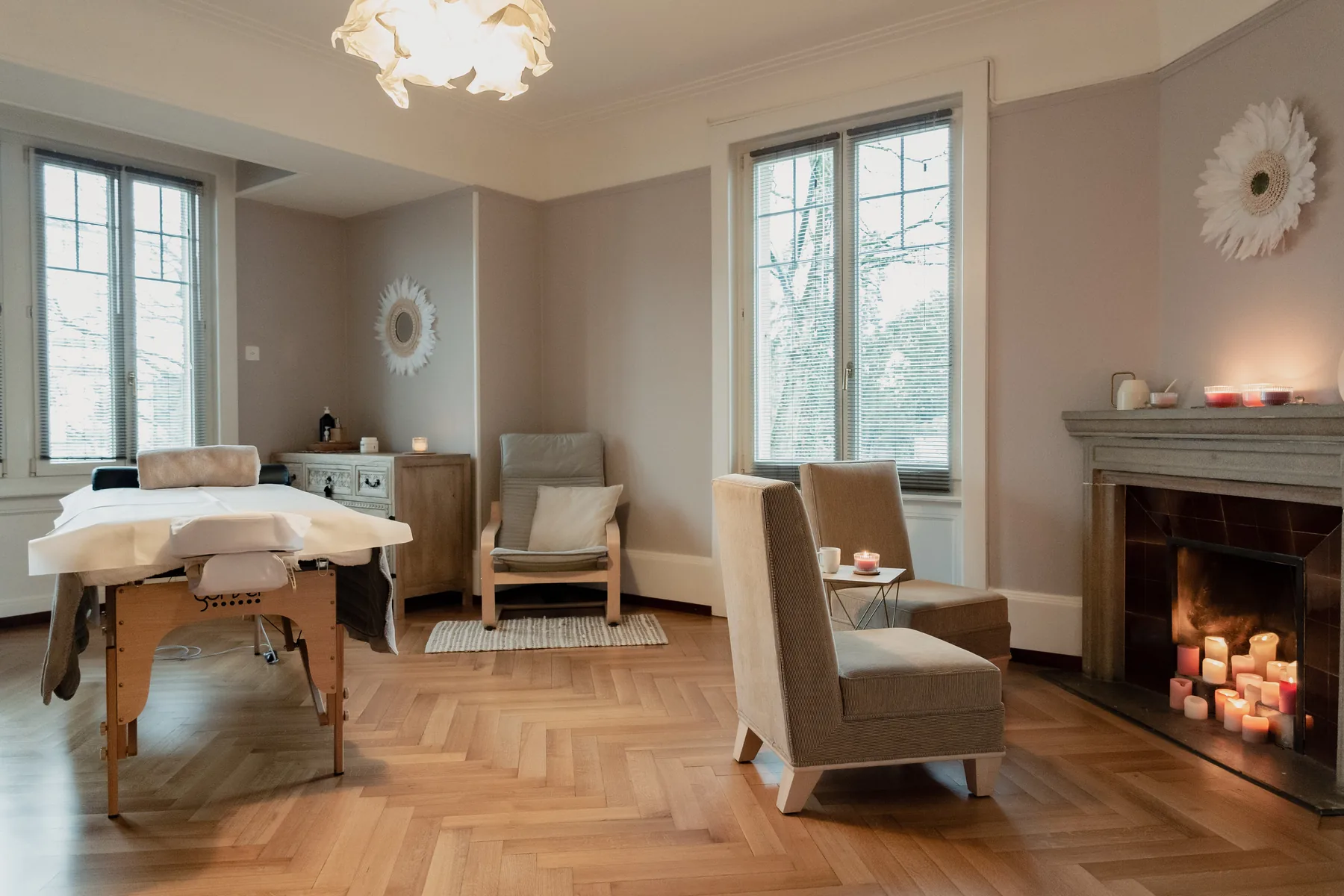 Le cabinet des Thérapies de Valérie à Lausanne, salon lumineux avec table de massage et cheminée